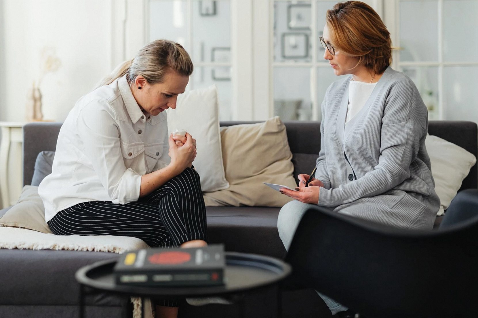A therapist and client in a counseling session, capturing feelings and support.